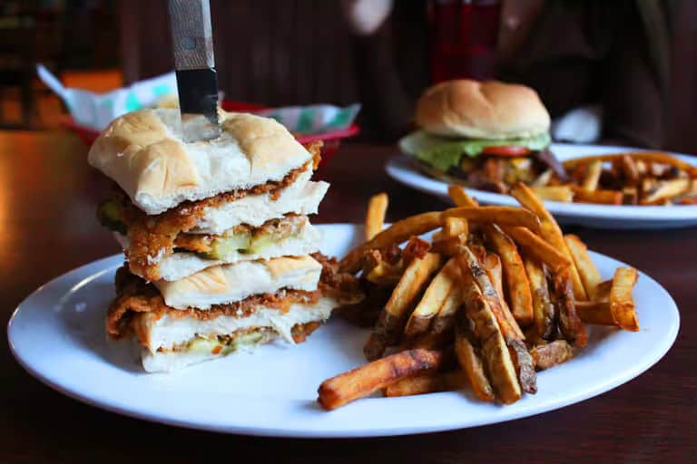 chicken sandwich and fries with a burger and fries in the background